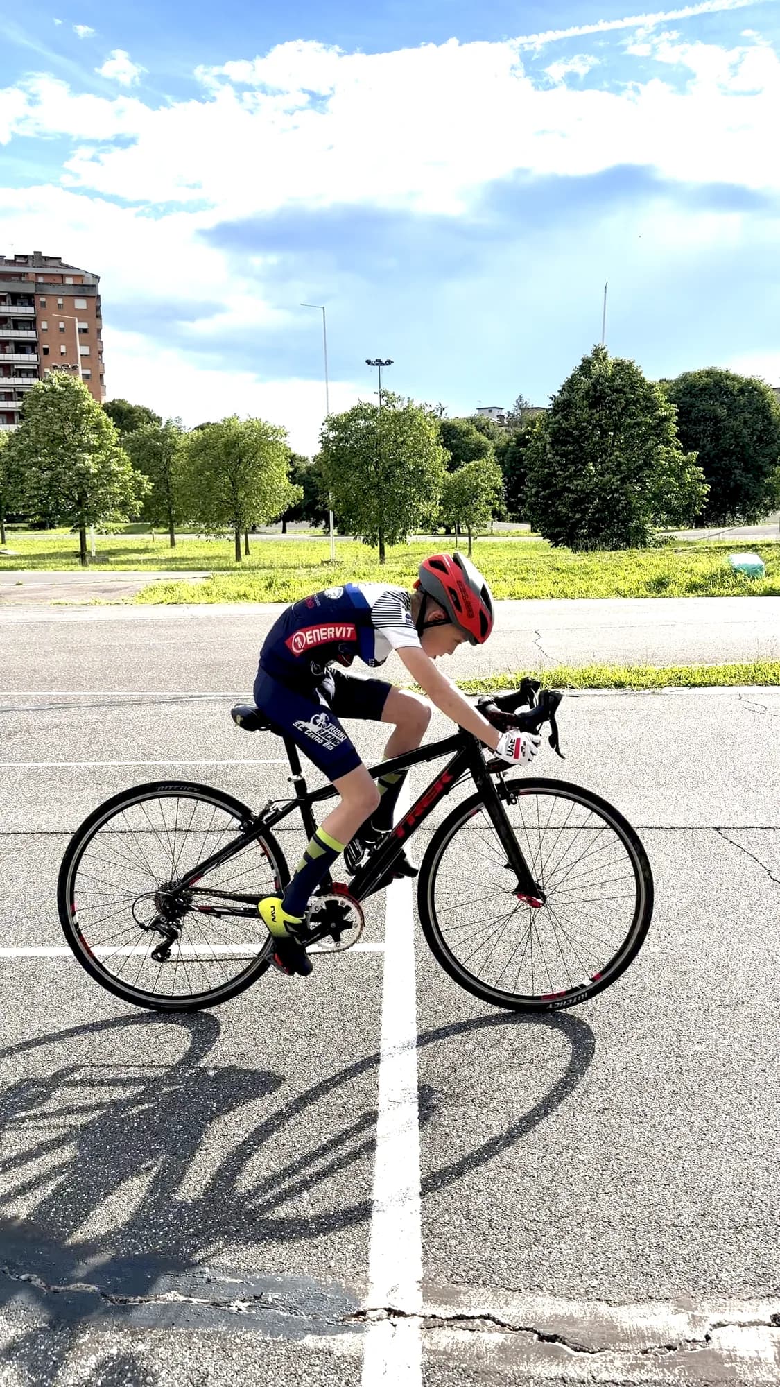 Giovane allievo della Scuola Triono pedala sulla bici da corsa lungo la pista del ciclodromo, in una giornata di sole